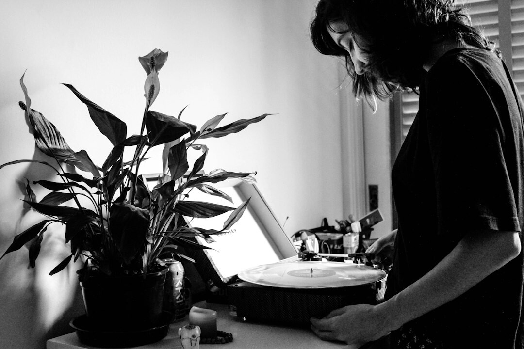 Person typing on laptop at a bright desk with plant